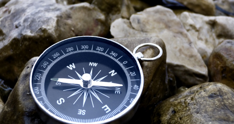 Compass on rocks with water