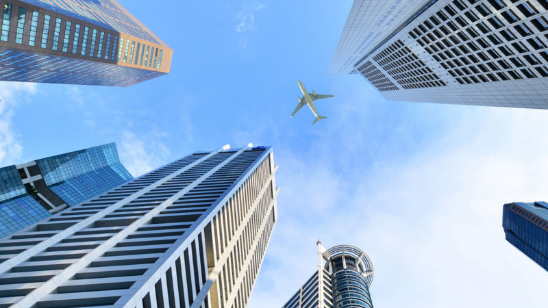 plane flying over buildings