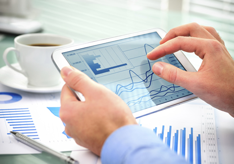 businessman_holding_ipad_with_charts